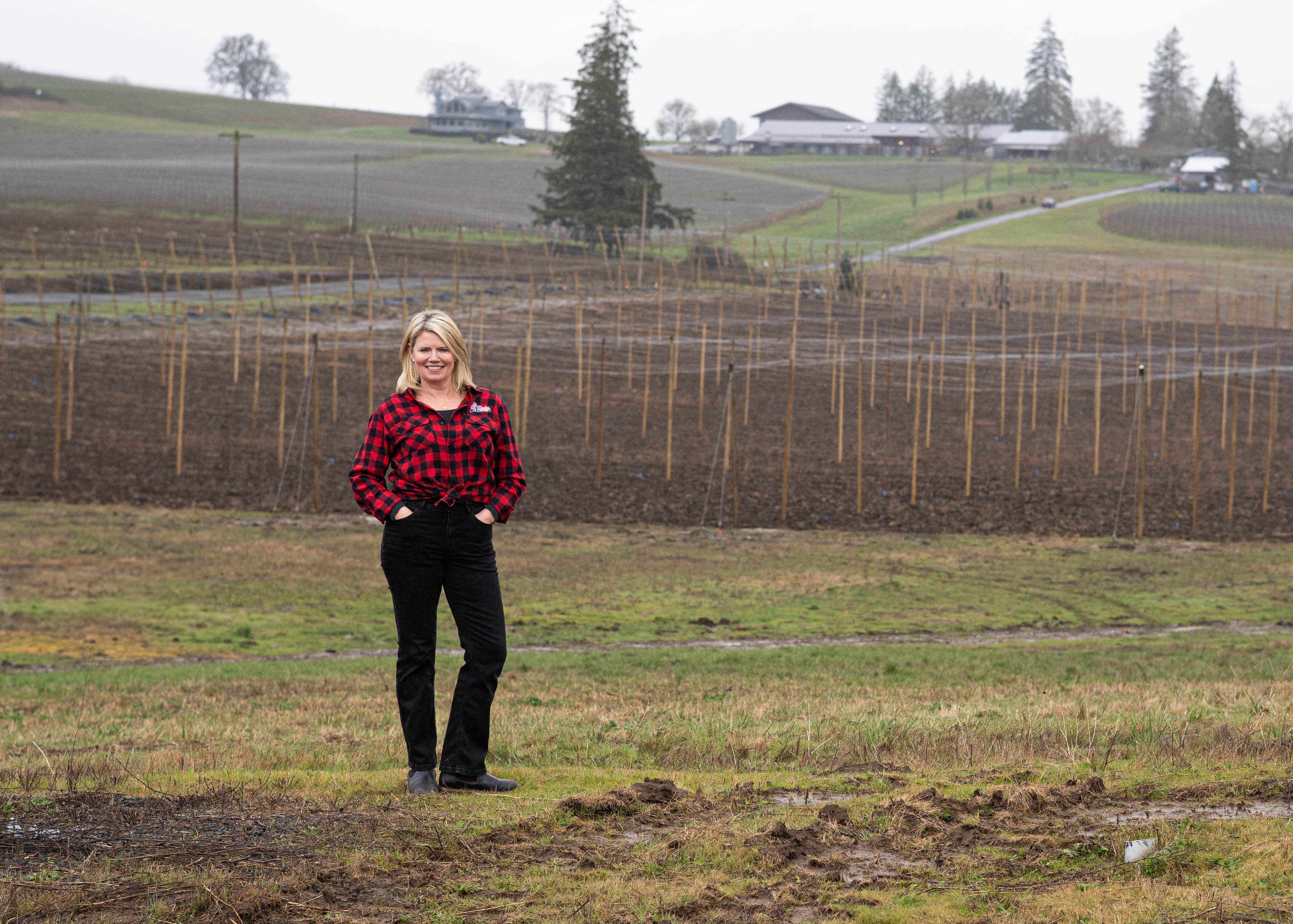 Shelly Bigley, owner of Root & Rye Hop Farm + Brewery, standing in front of her 15 acres of hop trellis. Photo: Branden Andersen / Newsberg