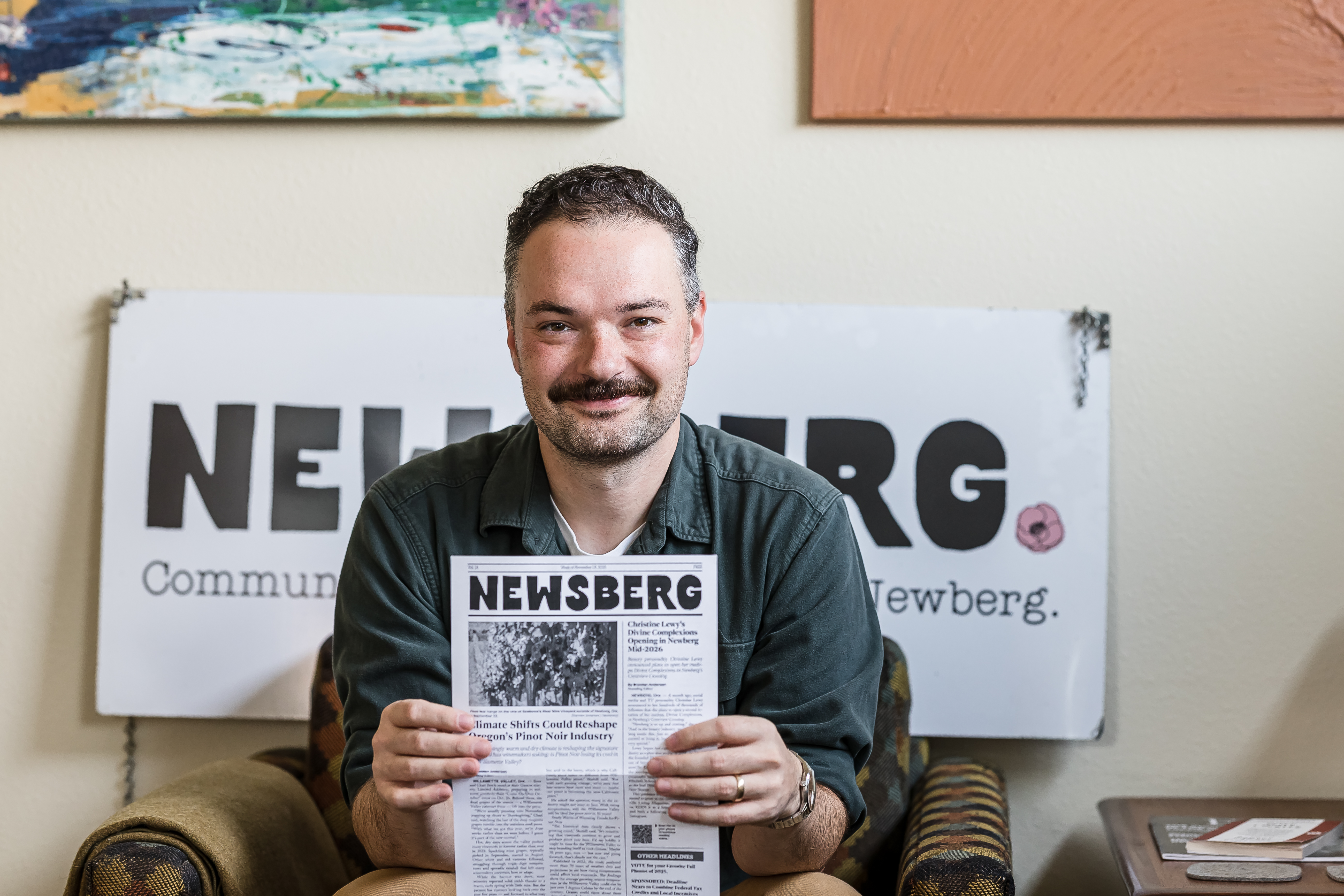 Newsberg Founding Editor Branden Andersen holding a Newsberg Print Newspaper at the Newsberg office in 2025.